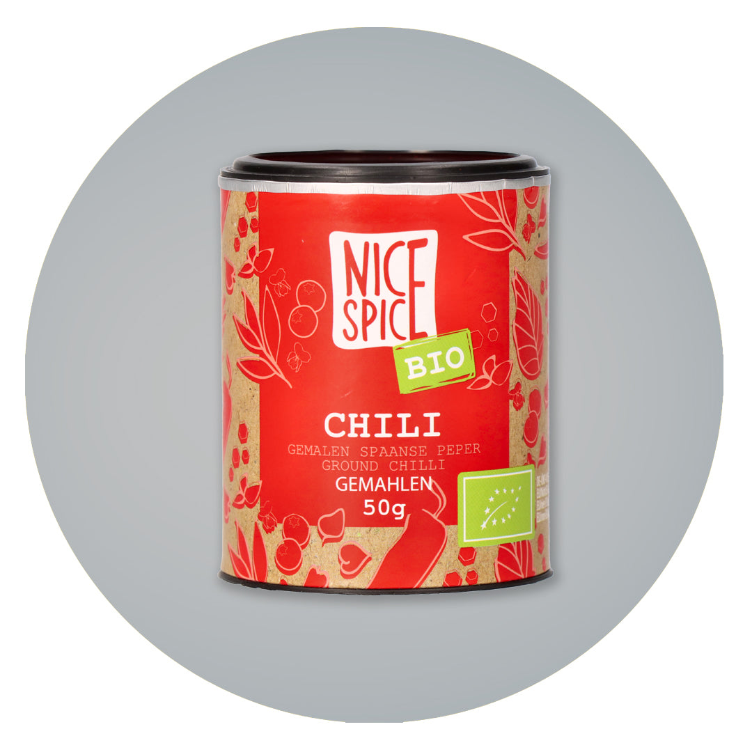 NICE SPICE Bio Chilipulver in roter zylinderförmiger Dose in verspieltem Design vor grauem Hintergrund